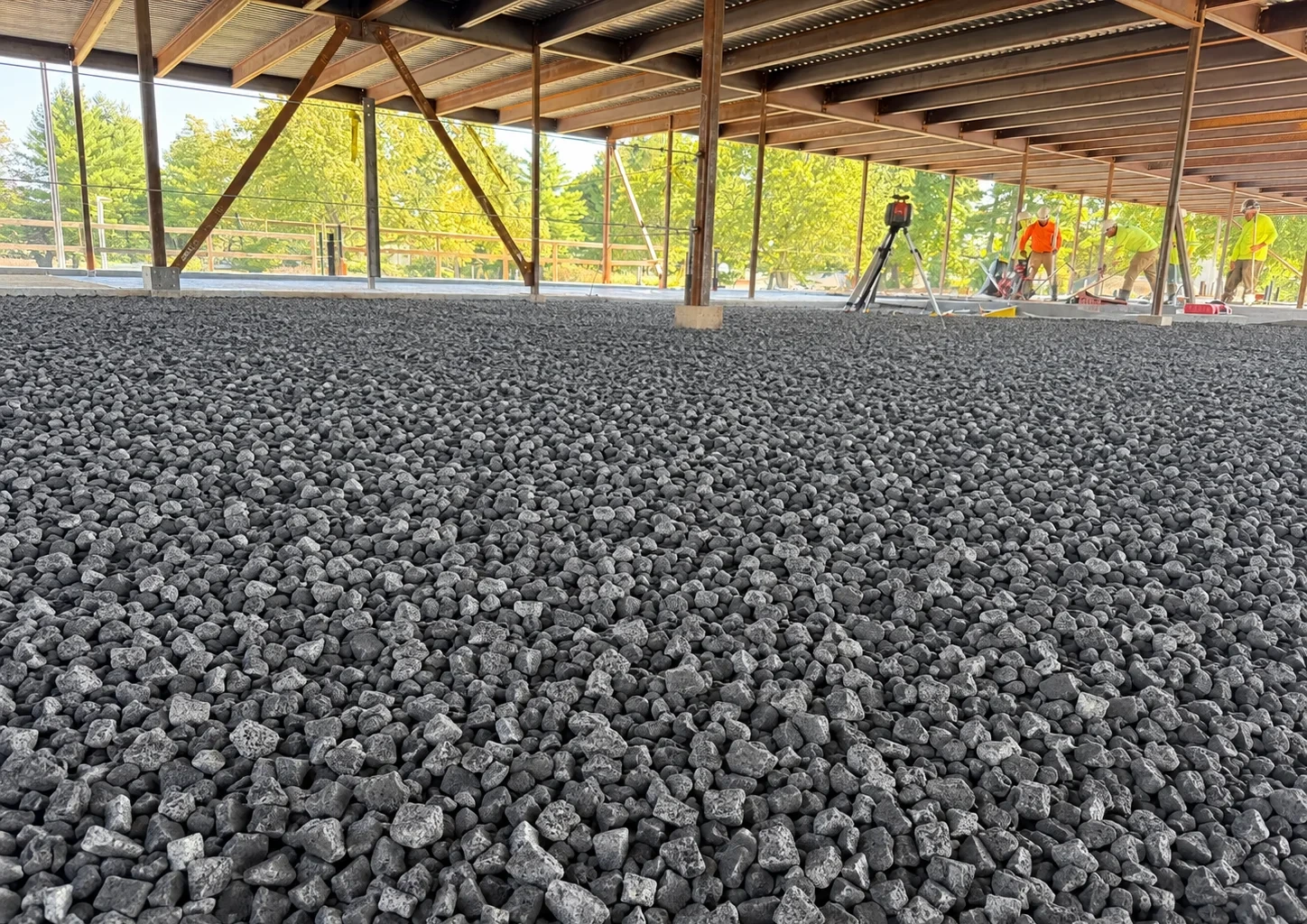 AI-edited illustration of foam glass aggregate spread in a flat, level layer inside a building